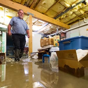 plumber wading through flooded basement